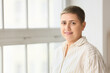 © Pixel-Shot - Portrait of young woman with short hair near window at home