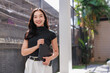 © crizzystudio - Young asian woman smiling holding digital tablet