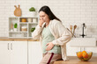 © Pixel-Shot - Young pregnant woman suffering from toxicosis near table in kitchen