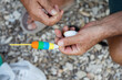 © Cavan Images - Man's hands attaching fishing float to line closeup