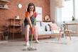 © Pixel-Shot - Young woman cleaning floor with mop at home