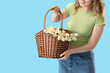 © Pixel-Shot - Young girl with basket and flowers on blue background