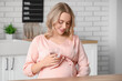 © Pixel-Shot - Young pregnant woman with glass of water in kitchen
