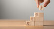 © Aytana - Arranging wooden blocks with icons for career path and development strategy concept. Success roadmap and journey symbolizing structured growth, planning, and progress.