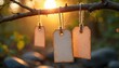 © miss irine - Three blank paper tags hang on twine from tree branch at sunset. Natural light illuminates rustic, eco-friendly labels set against soft, out-of-focus forest background, offering ample copy space for