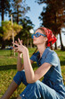 © SHOTPRIME STUDIO - lifestyle woman in modern boho-western denim street style with blue sunglasses and red bandana enjoys sunny outdoor park in film color tones