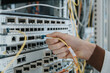 © Westend61 - Close-up of woman plugging fiber optic cable in equipment at data center