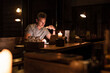 © Westend61 - Man having dinner looking at laptop
