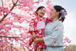 © geargodz - woman and child girl in yukata (kimono dress) with sakura flower or cherry blossom blooming in garden