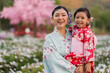 © geargodz - woman and child girl in yukata (kimono dress) with sakura flower or cherry blossom blooming in garden
