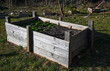 © Running opossum - raised wooden planter box in sunny garden preparing for spring vegetable planting