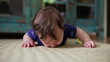 © Marco - Baby lying on mat, pressing face down with hands stretched forward, early movement exploration, sensory experience, discovering surroundings, infant development moment