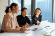 © FotoArtist - Diverse team collaborating on a laptop during a business meeting in a modern office