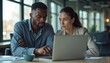 © Pete - Focused business colleagues analyze data on laptop in office. Man and woman collaborate on project work, deep in thought. Teamwork, study, and problem solving in modern workplace.