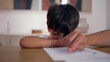 © Marco - Young boy struggling to focus on homeschooling worksheet, absentmindedly pointing at paper, feeling bored and distracted while trying to stay engaged in learning at home