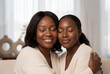 © Meow Creations - Affectionate black mother and daughter hugging with eyes closed in a tender family moment