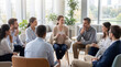 © Anastasiya - Group meeting in bright office lounge. Facilitator leads group discussion with coworkers seated in circle, sharing ideas, listening, coaching talk, teamwork mindset, business training concept