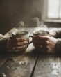 © choirul - Two hands holding steaming mugs of coffee on a rustic wooden table.