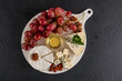 © ADDICTIVE STOCK - Cheese platter with grapes and honey on white board