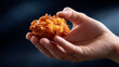 © Moddy - A hand presenting a crispy and delicious golden-brown food. The food is round and the texture looks very appealing