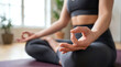 © Facundo - Close-up of a woman meditating in lotus pose with hands in mudra on a yoga mat indoors