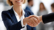 © Nataliya - Faceless businesswomen shaking hands at conference, professional greeting gesture, corporate networking moment, female business handshake, partnership introduction, defocused