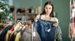 © JackF - Undecided young woman looking for jeans trousers in retail outlet with new winter collection