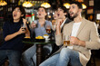 © JackF - Group of young male and female friends drink beer and celebrate after their team's victory at sports bar