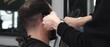 © rogerphoto - Skilled barber trimming client's hair using electric razor, creating contemporary hairstyle in modern barbershop setting with precise, professional technique