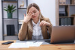 © New Africa - Woman feeling fatigue at wooden desk in office