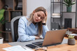 © New Africa - Woman feeling fatigue at wooden desk in office