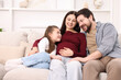 © New Africa - Pregnant woman, her husband and daughter on sofa at home. Space for text
