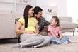 © New Africa - Pregnant woman, her husband and daughter on floor at home