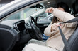© Nataliya - Portrait of a young pregnant woman fastening her seat belt in a car.