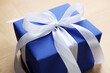 © New Africa - Beautiful gift box with bow on wooden table, closeup