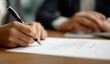 © andyaziz6 - Businesswoman signing a formal contract document with a black ballpoint pen on a wooden desk