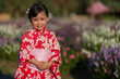 © geargodz - preschool child girl in yukata (kimono dress) with angelonia flower blooming in garden