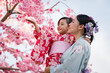 © geargodz - woman and child girl in yukata (kimono dress) with sakura flower or cherry blossom blooming in garden