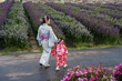 © geargodz - woman and child girl in yukata (kimono dress) walking together with flower blooming in garden