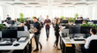 © Anwarul - Dynamic motion blur of diverse employees working and moving in a bright, modern open-plan office.