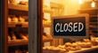 © Alex - Closed sign on bakery door symbolizing small business pause