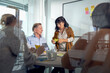 © Johnér - Senior businesswoman reading adhesive note standing next to colleague at office