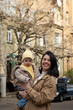 © phpetrunina14 - Mother holding toddler on city street in spring Portrait