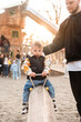 © phpetrunina14 - Father helping toddler balance on playground beam at sunset Family time