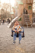 © phpetrunina14 - Toddler Enjoying Bucket Swing at Outdoor Playground Sunny day