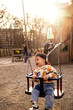 © phpetrunina14 - Toddler Enjoying Bucket Swing at Outdoor Playground Sunny day