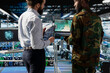 © DC Studio - Black military soldier works with engineer to strengthen national defense systems, protecting national servers in a huge data center. Using artificial intelligence for armed forces operations.