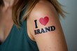 © Vera - Close-up Image of a Woman's Arm Displaying a Tattoo Declaring Affection for a Brand: I Love Brand