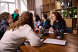 © master1305 - Young women discussing ideas at modern workspace table. Concept of creative collaboration, student teamwork, informal business meeting, startup development, coworking culture.