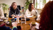 © master1305 - Young women listening attentively during team strategy session. Concept of focused participation, collaborative planning meeting, professional development workshop, startup teamwork.